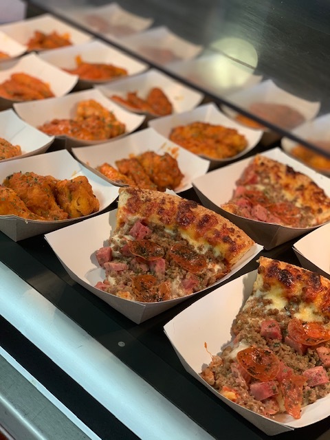 Meat-lovers pizza and buffalo wings at Ballpark station in High School cafeteria